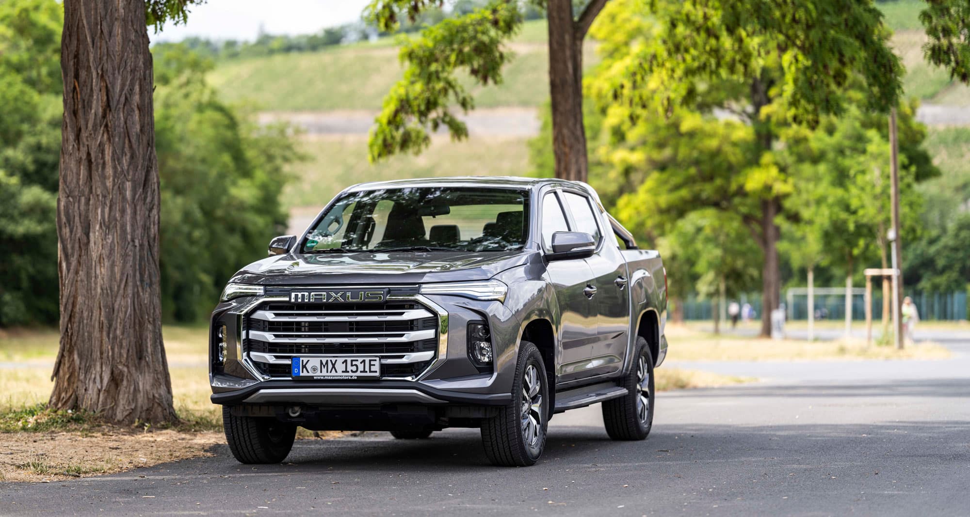 Maxus T90 EV geparkeerd onder een boom