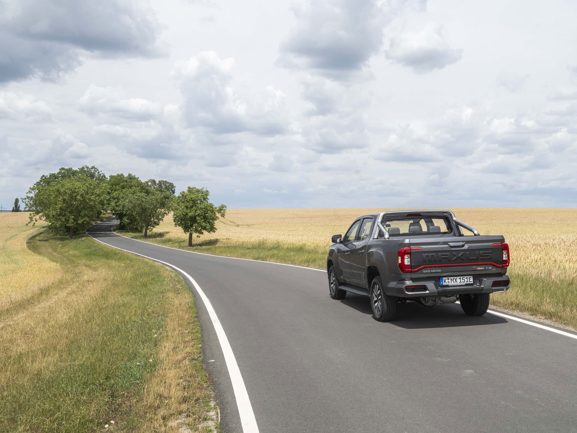 Maxus T90 EV Grijs rijdend tussen velden