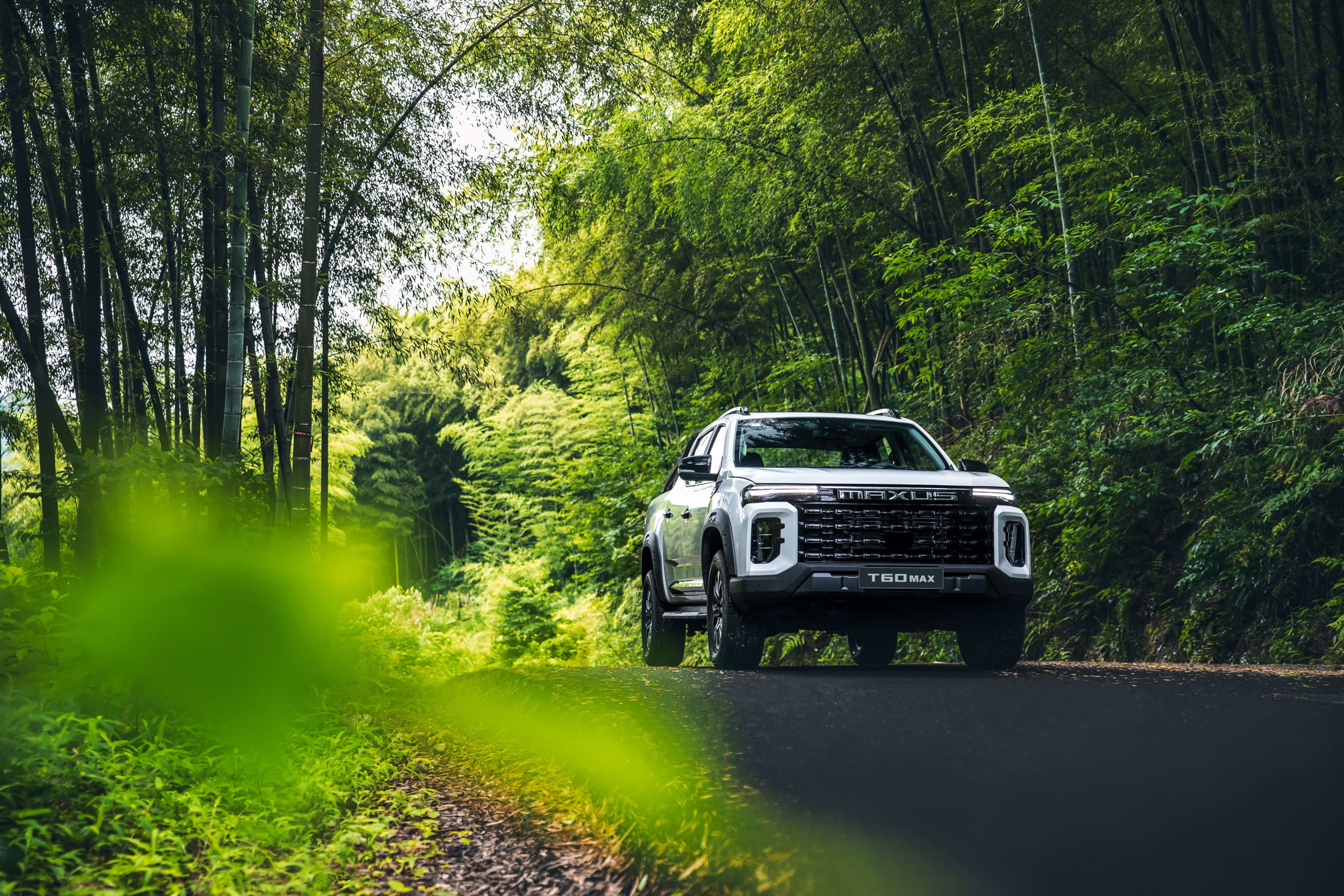 Maxus T60 Max driving in a forest front - warm white