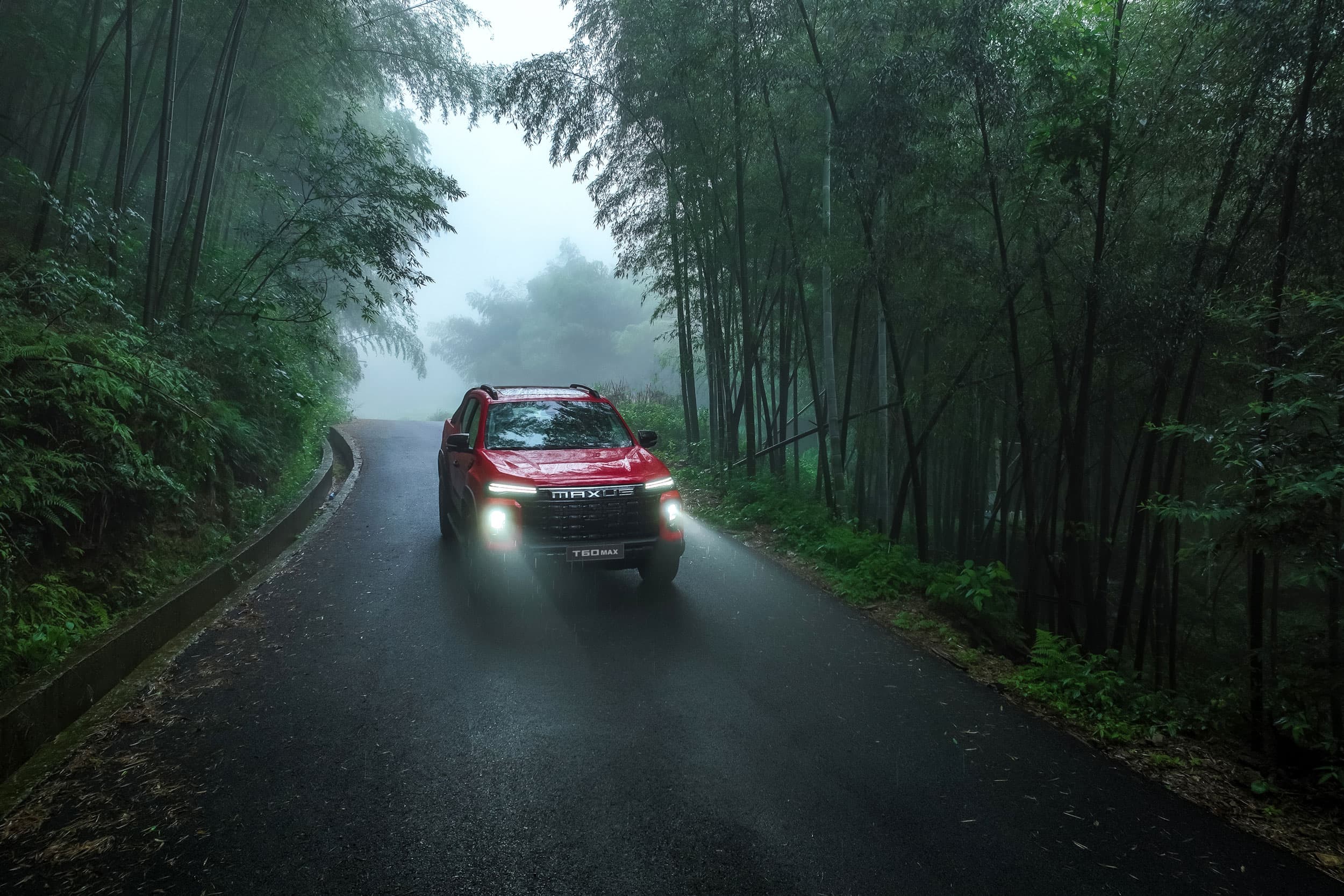 Maxus T60 Max driving in a forest (chinese red)