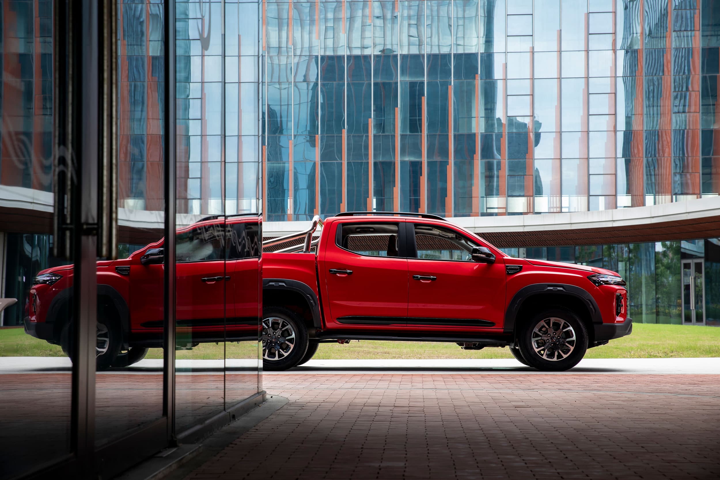 Maxus T60 MAX mirrored in building sideview (chinese red)